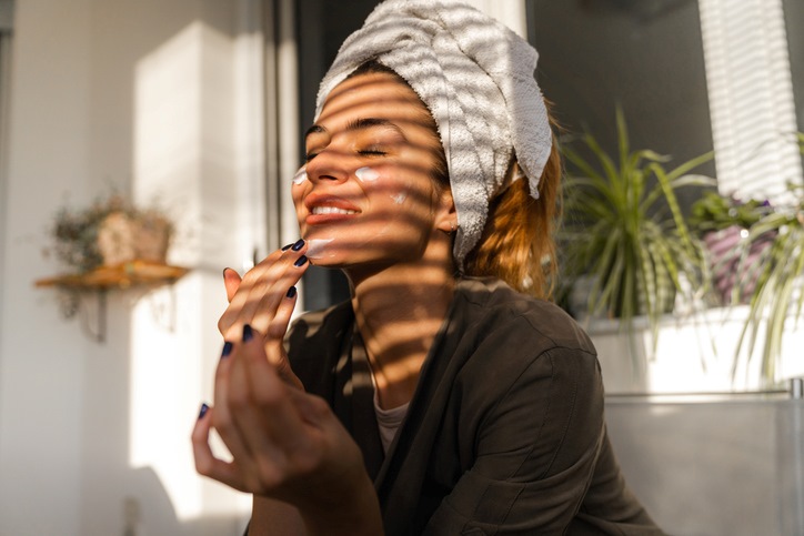Person With Towel on Head Applying Cream in Sunlight in Palm Coast, FL
