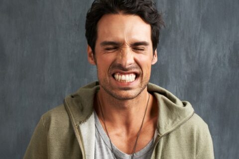 Person clenching teeth, demonstrating teeth grinding issue