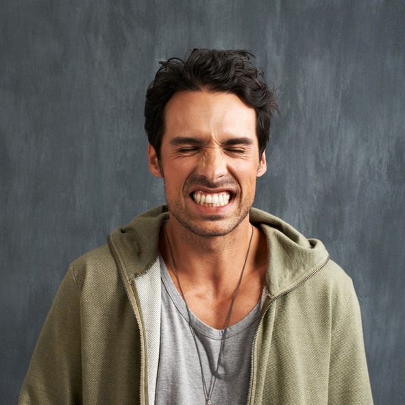 Person clenching teeth, demonstrating teeth grinding issue